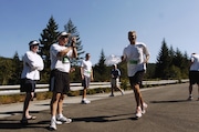 Joe Gilliam (cq) runs past his team "Fred Meyer" who had stopped to give their support as he ran by coming down the hill on leg two.. Mt Hood looms in background on a hot sunny day for the Hood to Coast runners LC- The Oregonian