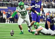 Oregon quarterback Bo Nix (10) and offensive lineman Jackson Powers-Johnson (58) go to cover the ball after Nix lost it during the second half of the Pac-12 championship NCAA college football game against Washington, Friday, Dec. 1, 2023, in Las Vegas. The play was ruled a dead ball after review. (AP Photo/David Becker)