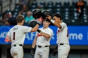 Oregon State outfielder Gavin Turley (left) celebrates a home run with Dallas Macias and Micah McDowell (right) during the Beavers' 11-1 win over Michigan at Globe Life Field in Arlington, Texas. (Photo by Mario Terrana)