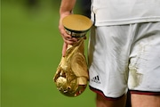 Germany's national player Lukas Podolski leaves the pitch with the World Cup trophy in his hand, wearing Adidas after winning the World Cup final soccer match in Rio de Janeiro, Brazil, Sunday, July 13, 2014. The German Football Association DFB announced today, that Nike will replace Adidas as the new supplier of the national teams from 2027.
