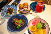 Plantain brioche muffins, akra, octopus and twice cooked pork are served at Kann, a Haitian restaurant by Gregory Gourdet in Portland, on Thursday, November 10, 2022.