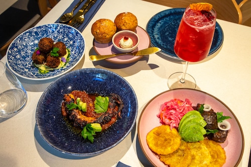 Food on blue and pink plates on a white table