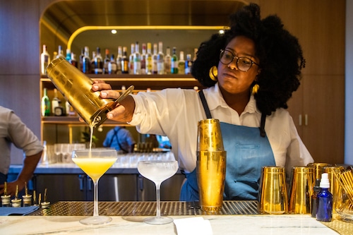 A bartender pours a cocktail